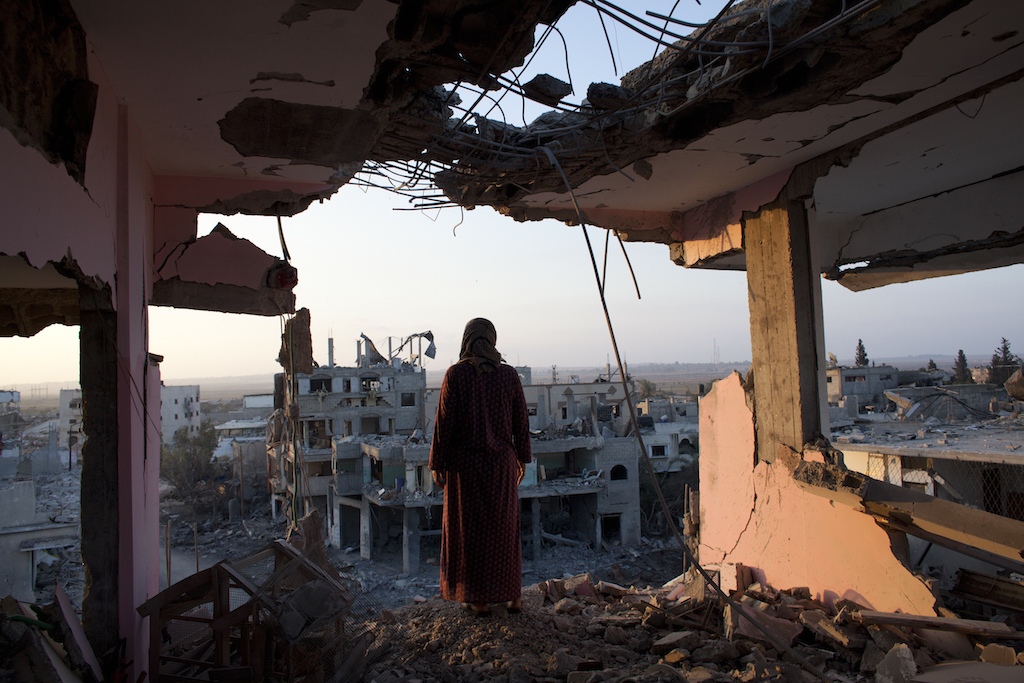 A Palestinian woman overlooks the destruction in Shujayea at dawn Aug. 8, 2014. On Friday the 72 hour cease fire came to an end without a longer term agreement . Rockets fired by Palestinian militants hit Israel and Israel resumed its air strikes .(Photo by Heidi Levine/For The National/Sipa Press).
