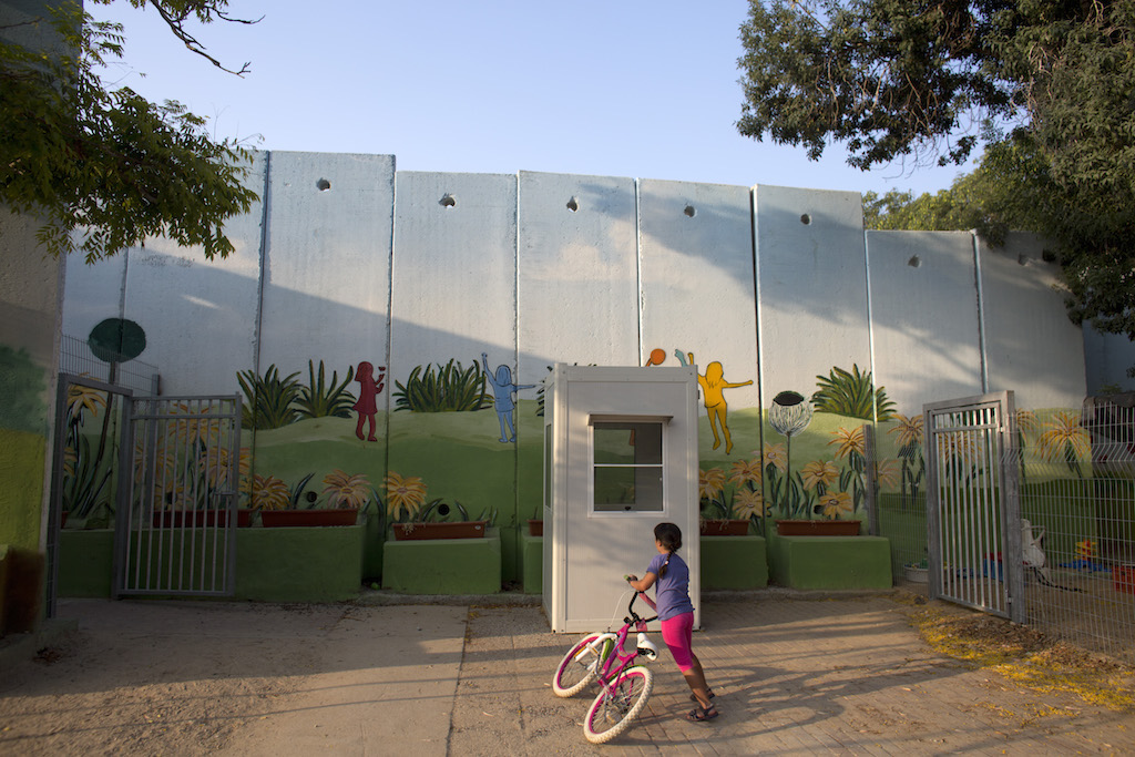 A young Israeli girl outside the kindergarden in Kibbutz Nahal Oz which has now been fortified by a series of cement  security walls to help ensure the children's safety ever since last summer's war between Israel and the Hamas-controlled Gaza Strip.The security wall has been painted to help the children feel more at ease .(Photo by Heidi Levine for The Globe and Mail).